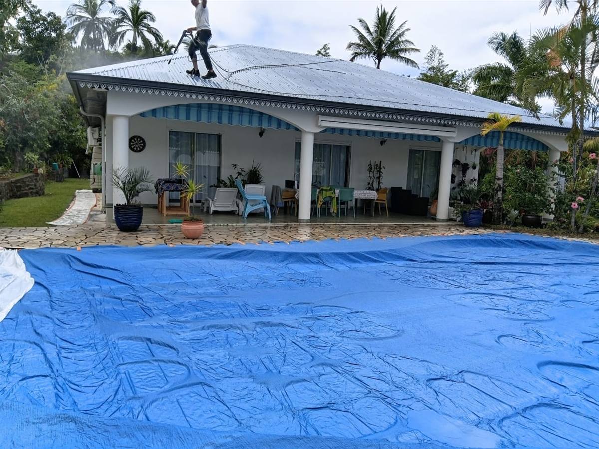 Couvreur d'Entreprise Bernasconi appliquant la peinture sur une toiture en tôle